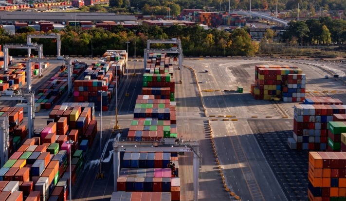 A lot filled with multicolor freight transportation boxes, suggesting global trade and economics